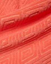 Mens Tristan Short in bold coral terry cloth, featuring a luxurious plush texture and an intricate, all-over embossed geometric maze pattern, reflecting refined streetwear style. (6)