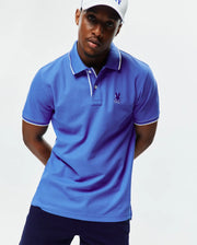 Mens Brad Pique Polo in royal blue, featuring a classic fit, pique knit fabric, white tipped collar and cuffs, and a small embroidered purple Psycho Bunny skull logo on the left chest. (1)