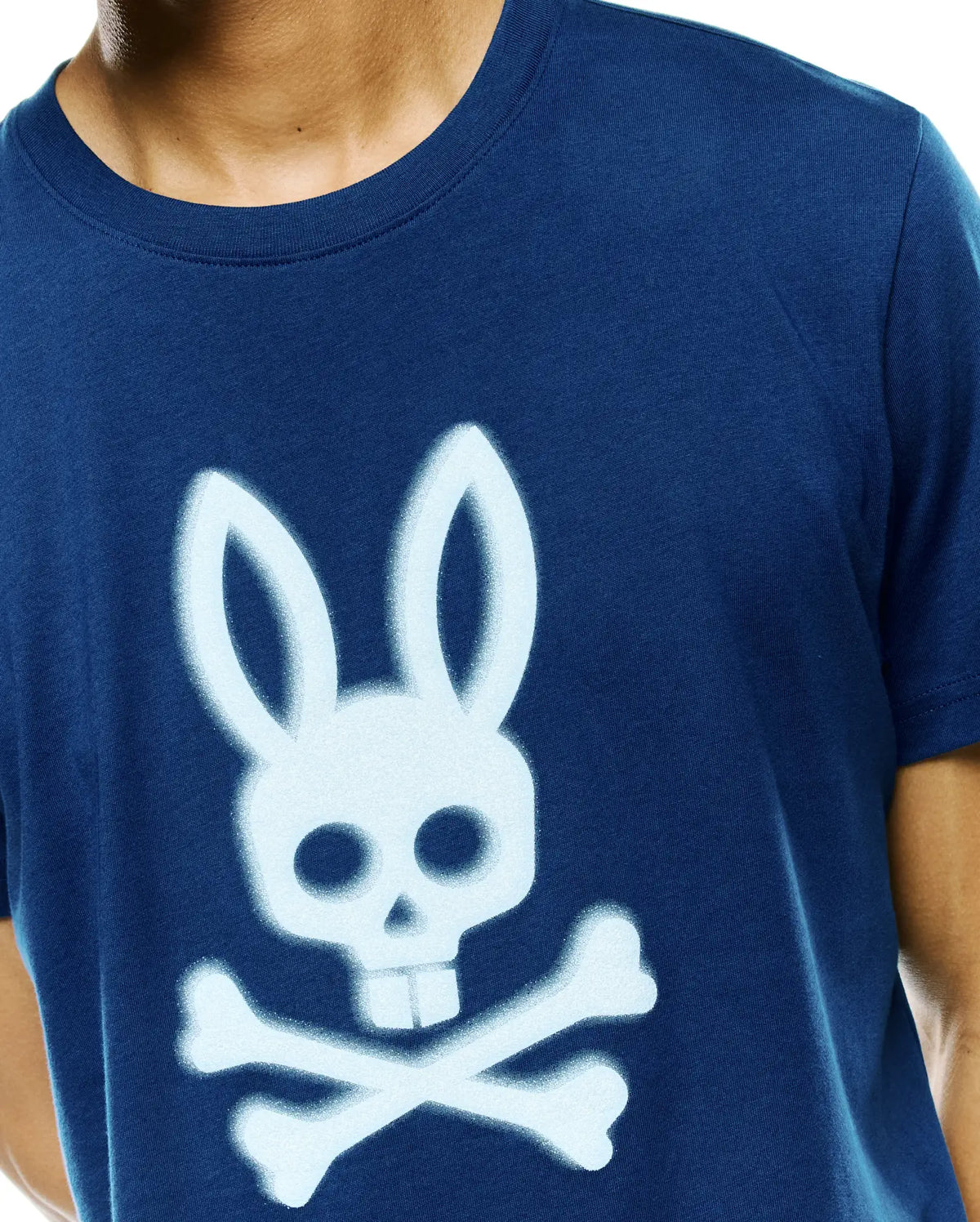 Mens Emmanuel Graphic Tee, a classic fit navy blue jersey t-shirt featuring a large, light blue spray-painted Psycho Bunny skull and crossbones graphic on the center chest. (3)