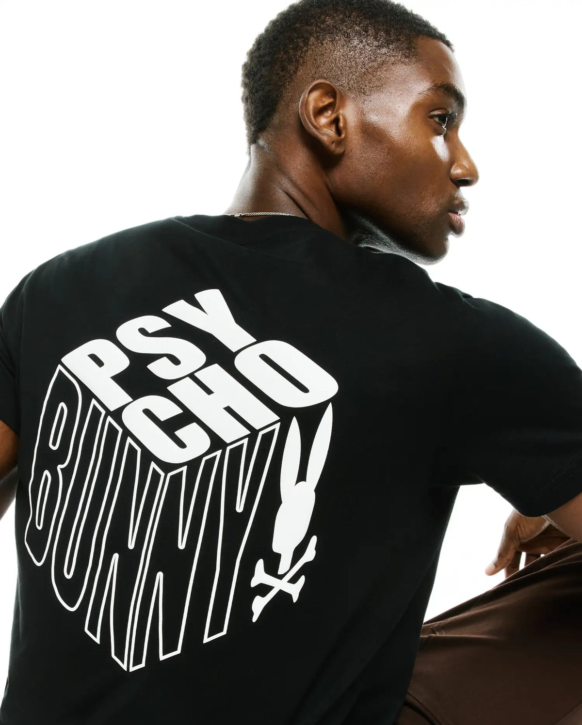 Men's Conan Pima Back Graphic Tee, a black classic fit Pima cotton jersey t-shirt featuring a large white 3D-effect Psycho Bunny text graphic and iconic bunny skull logo on the back. (1)