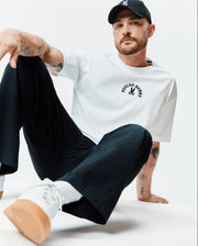 Mens Stevie Relaxed Fit Tee, white smooth jersey, featuring a black arched Psycho Bunny text and iconic bunny skull logo centered on the chest. (3)