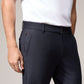 A person wearing Psycho Bunny's men's Gable regular fit sport pants made of stretch cotton-nylon stands with their left hand in their pocket, showing a partial side and back view. The focus is on the fit of them.