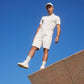 A man standing on a ledge, dressed in MENS OUTLINE SWEATSHORT - B6R507X1CN by Psycho Bunny.