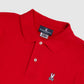 Close-up of a red Men's Classic Polo - B6K001CRPC with a white Psycho Bunny logo on the chest and a tag on the collar displaying the brand name and size.