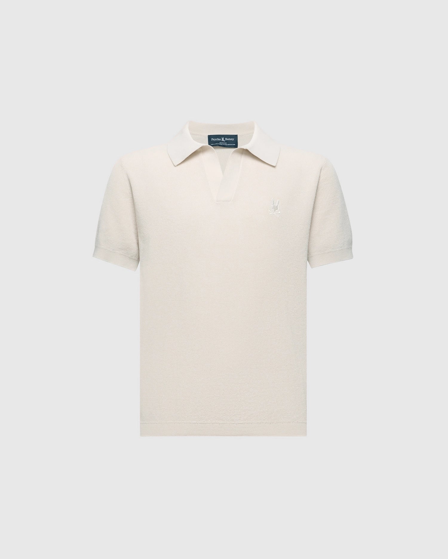 The Psycho Bunny KIDS LEETON JOHNNY COLLAR KNIT POLO (B0E562F200) is a white short-sleeve polo in 100% cotton with a buttonless collar, set against light gray. A small embroidered bunny logo on the left chest makes it ideal for transitional wear.