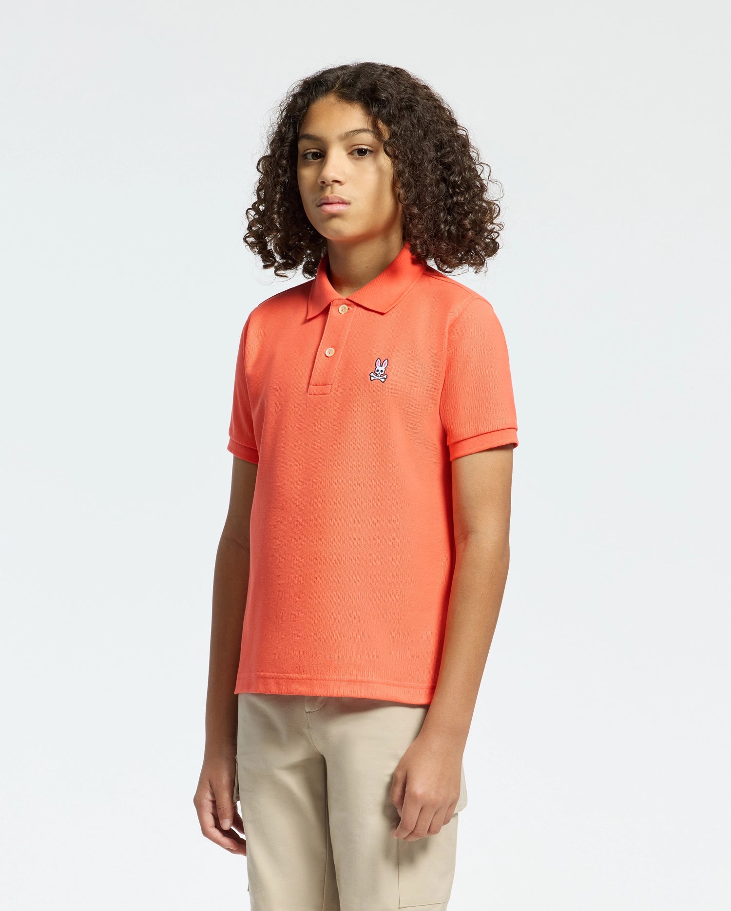 Kids | Kids' hot coral Psycho Bunny classic polo with embroidered logo, ribbed collar, and soft Pima cotton fabric for comfort and style.