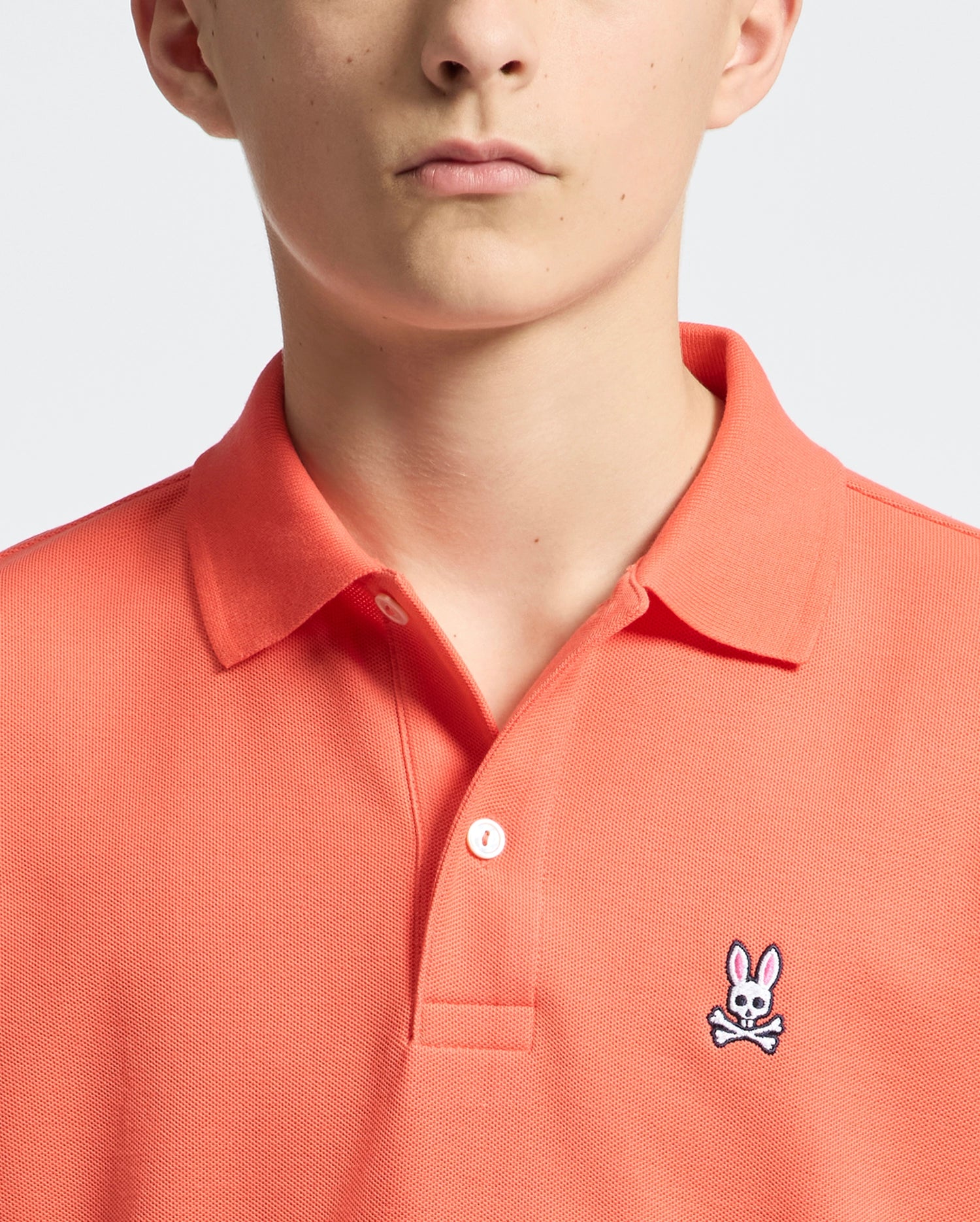 Teen | Kids' hot coral Psycho Bunny classic polo with embroidered logo, ribbed collar, and soft Pima cotton fabric for comfort and style.