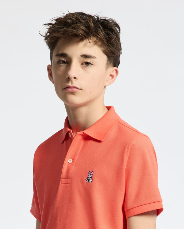Teen | Kids' hot coral Psycho Bunny classic polo with embroidered logo, ribbed collar, and soft Pima cotton fabric for comfort and style.