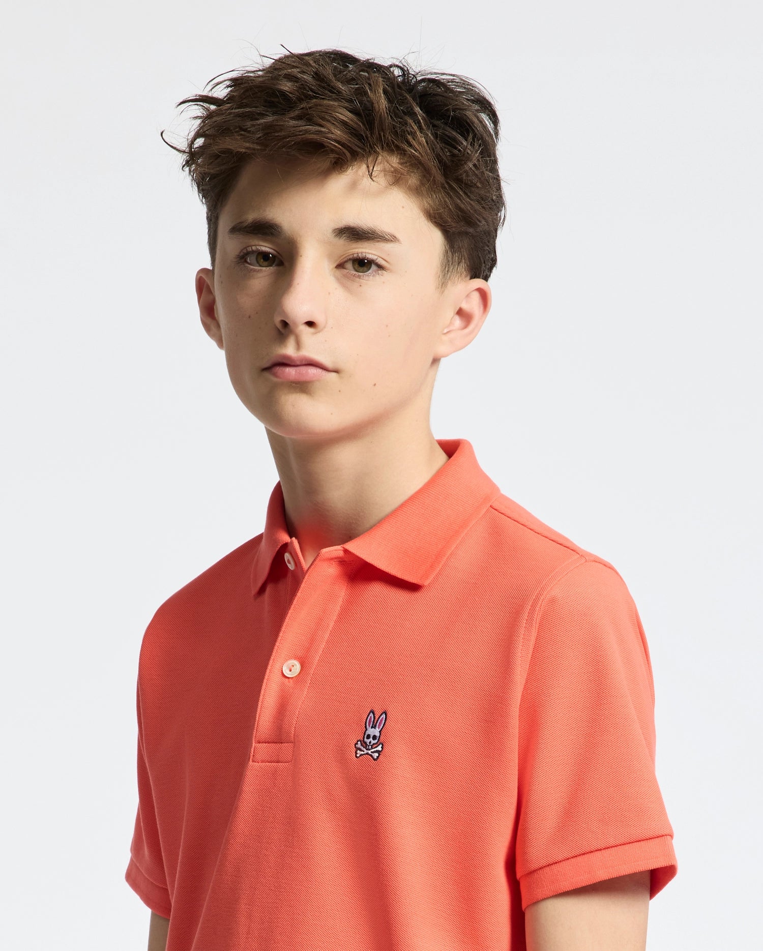 Teen | Kids' hot coral Psycho Bunny classic polo with embroidered logo, ribbed collar, and soft Pima cotton fabric for comfort and style.