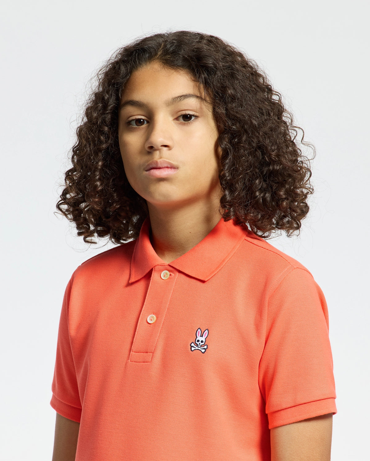 Kids | Kids' hot coral Psycho Bunny classic polo with embroidered logo, ribbed collar, and soft Pima cotton fabric for comfort and style.
