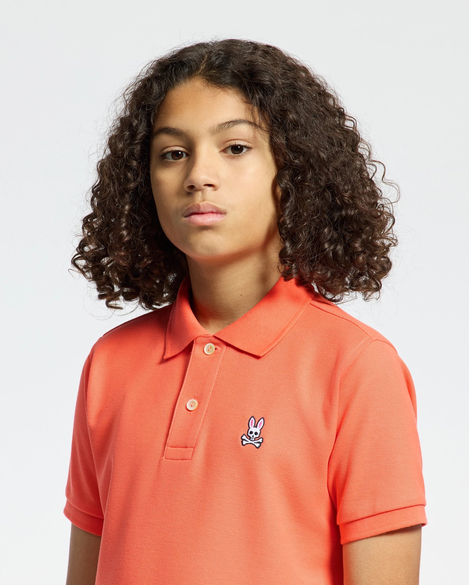 Kids | Kids' hot coral Psycho Bunny classic polo with embroidered logo, ribbed collar, and soft Pima cotton fabric for comfort and style.