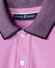 A close-up of a pink Psycho Bunny KIDS SOUTHPORT PIQUE POLO SHIRT - B0K263B200.