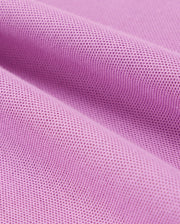 A close-up of a piece of pink Pima cotton fabric with a textured, waffle-like pattern. The fabric has several folds and appears soft, showcasing its detailed weave and structure. This is characteristic of the KIDS SOUTHPORT PIQUE POLO SHIRT - B0K263B200 by Psycho Bunny.