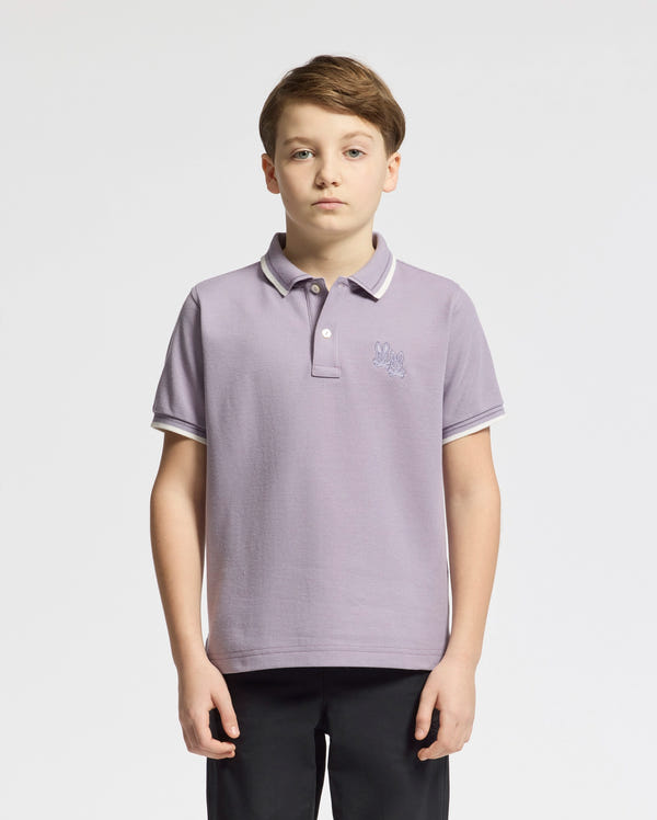 A boy with short brown hair wears a stylish Psycho Bunny Kids Elliot Pique Polo, color light purple, against a plain white background, looking at the camera with a neutral expression.