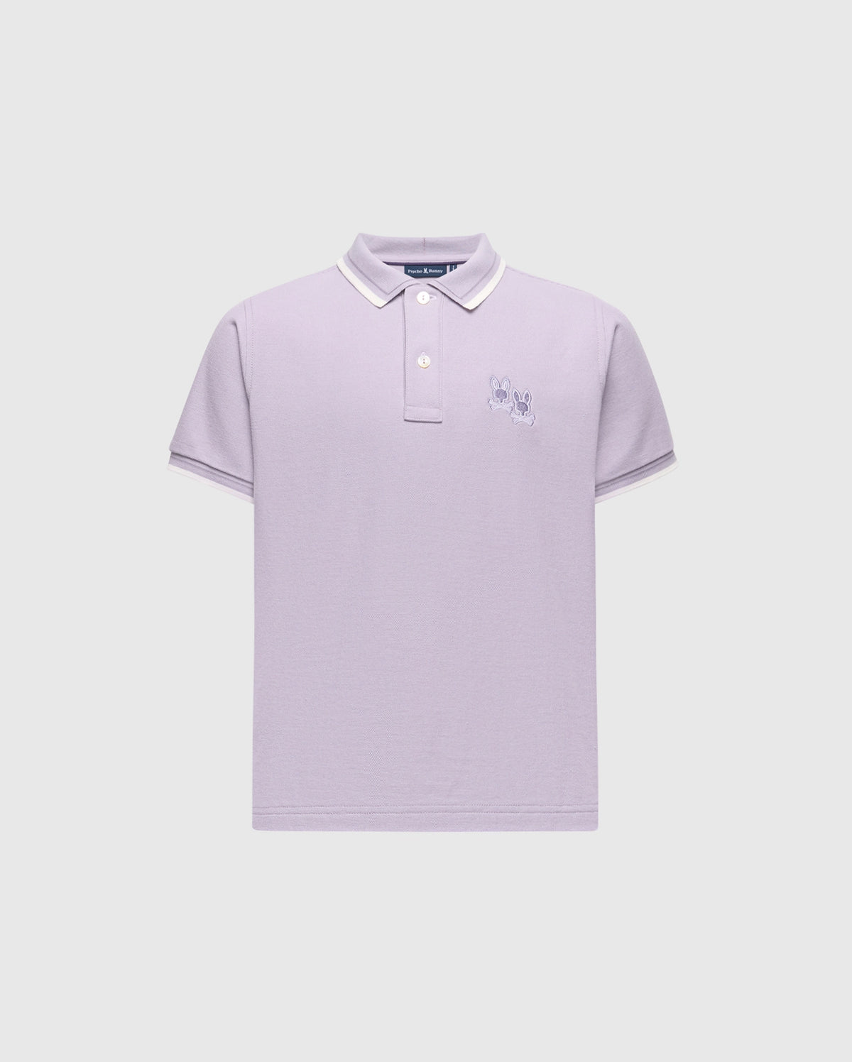The KIDS ELLIOT PIQUE POLO - B0K505F200 by Psycho Bunny is a stylish lavender Pima cotton polo with white trim on the collar and sleeves. It features two cartoon-like rabbits embroidered on the left chest against a light gray background.