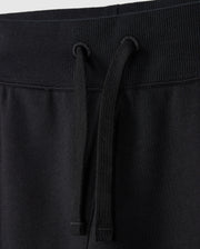 Close-up of the waistband of a pair of Psycho Bunny KIDS LEVY ESSENTIAL FLEECE SWEATPANTS (B0P721D200), showcasing the ribbed elastic band and black drawstrings hanging down the front. The fabric looks soft and smooth, making it perfect for cozy playtime.