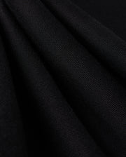Close-up of folded black fabric with a smooth, textured surface, reminiscent of the KIDS PACIFIC CHENILLE JOGGER - B0P972D200 by Psycho Bunny. The material appears soft and evenly pleated, showcasing its fine fibers and subtle sheen under the light.