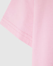 Close-up of the sleeve of a light pink Psycho Bunny KIDS CLASSIC CREW NECK TEE - B0U014CRPC against a plain background, showcasing the 100% Pima cotton fabric texture and stitching detail. An ideal pick for back-to-school outfits.