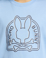 The KIDS MELBOURNE GRAPHIC TEE - B0U410F200, by Psycho Bunny, features a logo with an abstract rabbit head above crossed bones and "Psycho Bunny" on either side. It's crafted from eco-friendly Peruvian Pima cotton in blue.