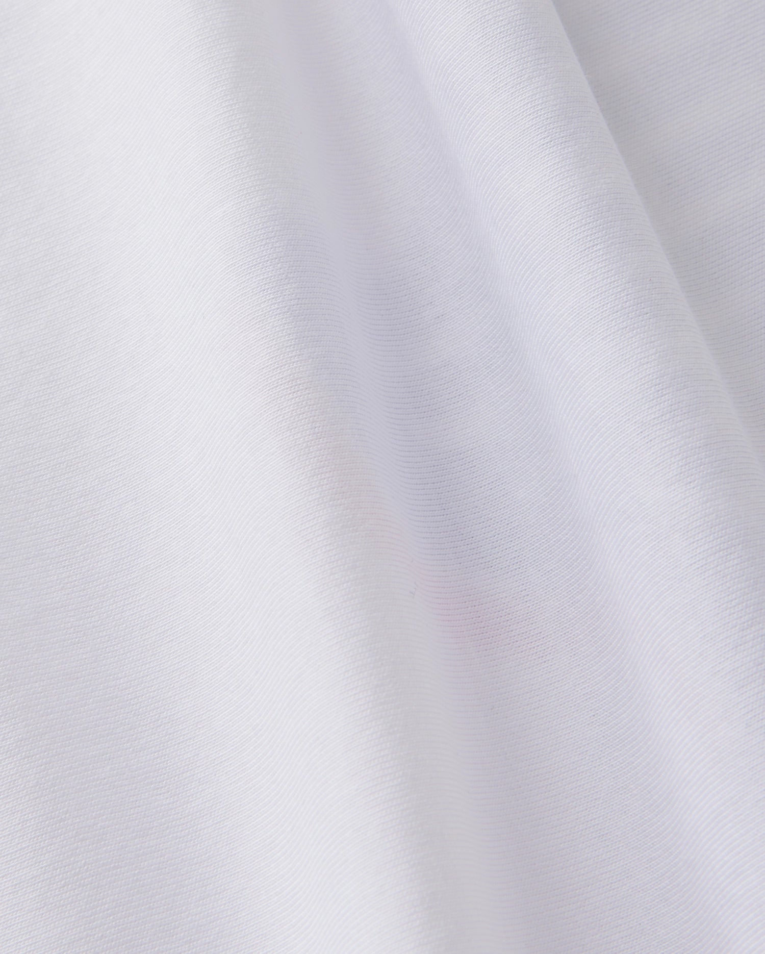 A close-up of the soft, white Peruvian Pima cotton fabric of the KIDS TEXAS CITY TEE - B0U553B2PC by Psycho Bunny shows subtle folds and texture, creating gentle shadows and highlights.