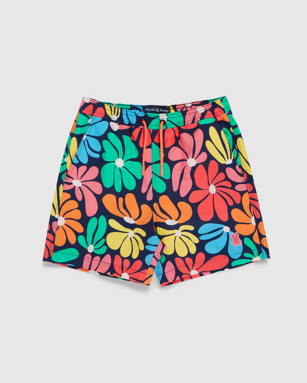 The KIDS MENTZ SWIM TRUNK - B0W320B2SW by Psycho Bunny is a pair of vibrant quick-dry swim trunks featuring a colorful floral pattern with large, abstract flowers in shades of orange, red, green, blue, and pink set against a white background. The shorts are designed with an elastic waistband and a red drawstring.