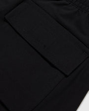 Close-up of a black polyester mechanical stretch fabric with a detailed view of a stitched rectangular patch pocket on Psycho Bunny's KIDS MALTA HYDROCHROMIC SWIM TRUNK - B0W321B2SW.
