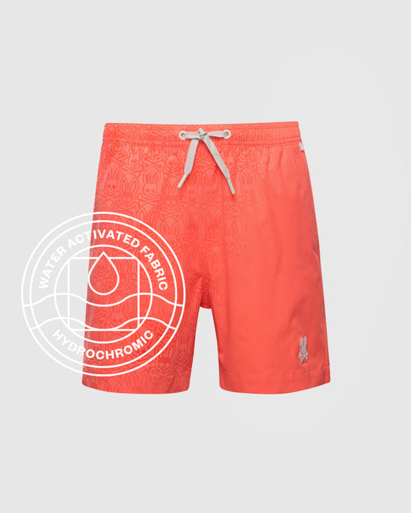 The Psycho Bunny KIDS SAMOS HYDROCHROMIC SWIM TRUNK (B0W453F200) features coral fabric with a white drawstring, subtle pattern, and a small white bunny logo. Water-activated hydrochromic fabric and quick-dry tech included.