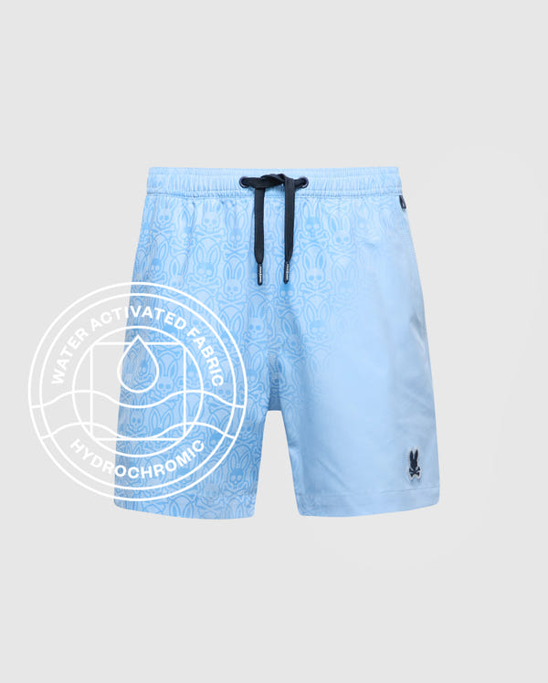 The Psycho Bunny KIDS SAMOS HYDROCHROMIC PRINTED SWIM TRUNK (B0W453F200) features a light blue subtle pattern, black drawstring, and black logo. "Water Activated Fabric Hydrochromic" highlights its innovative color-changing technology.