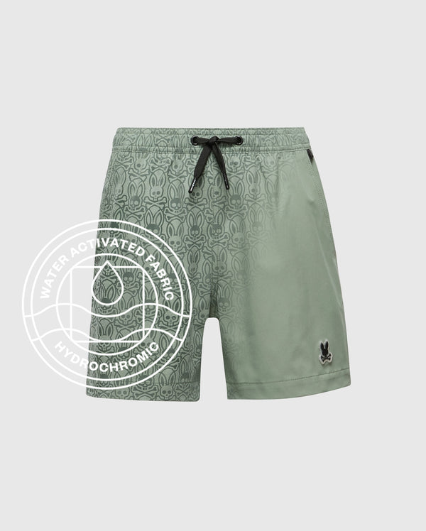 The Psycho Bunny KIDS SAMOS HYDROCHROMIC PRINTED SWIM TRUNK - B0W453F200 features a light green color, black drawstring, subtle bunny pattern, and hydrochromic "Water Activated Fabric" technology highlighted by a water drop icon.