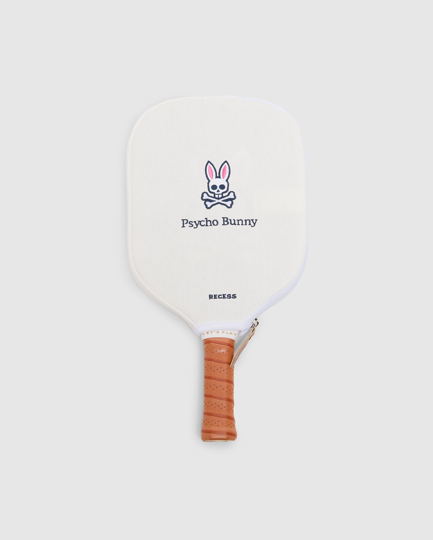 The PICKLEBALL PADDLE WITH COVER - B6A277E200 by Psycho Bunny features a white face, tan leather grip, and an embroidered pink and black bunny logo above "Psycho Bunny," plus a polypropylene honeycomb core.