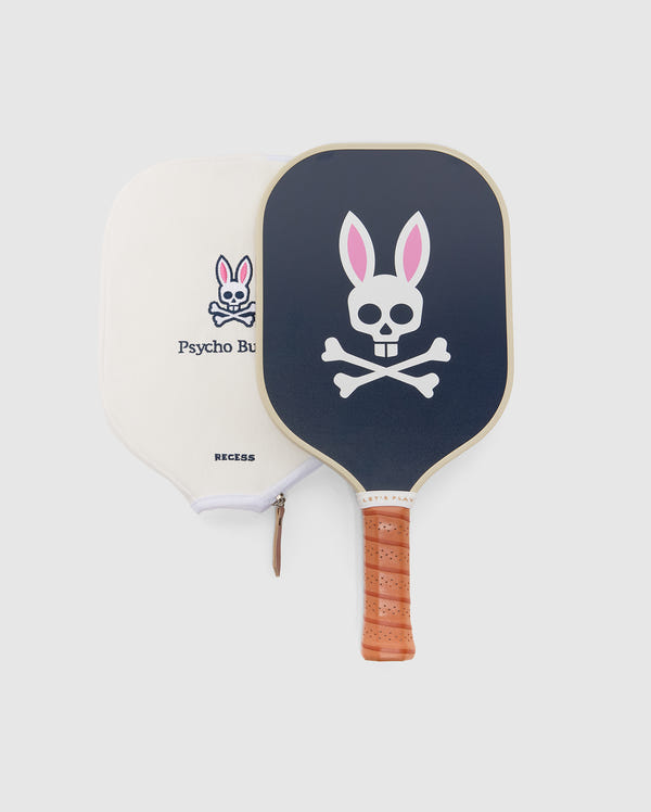 The Psycho Bunny PICKLEBALL PADDLE WITH COVER - B6A277E200 features a black paddle with a pink-eared bunny and crossbones, a fiberglass blend honeycomb core, and comes with a cream zippered cover with the Psycho Bunny logo.