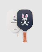 The Psycho Bunny PICKLEBALL PADDLE WITH COVER - B6A277E200 features a black paddle with a pink-eared bunny and crossbones, a fiberglass blend honeycomb core, and comes with a cream zippered cover with the Psycho Bunny logo.