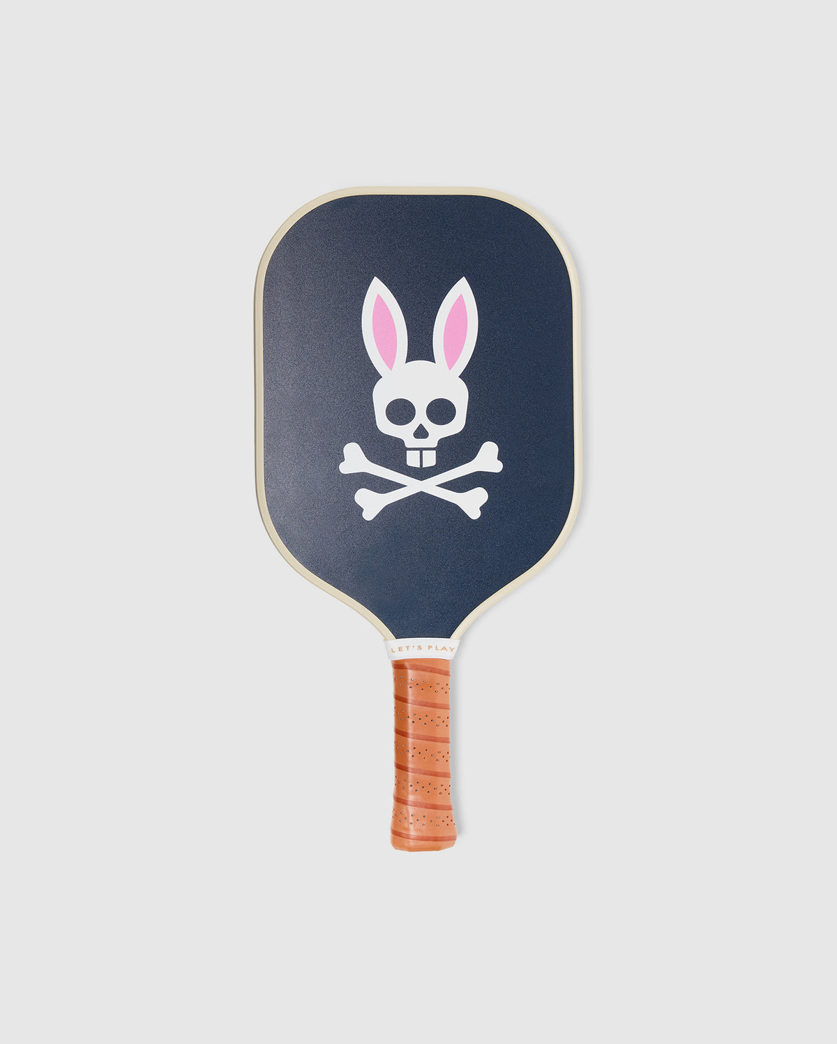 The Psycho Bunny PICKLEBALL PADDLE WITH COVER - B6A277E200 is dark blue with a brown leather grip, featuring a white skull and crossbones with pink and white bunny ears, and a durable honeycomb core for power and control.