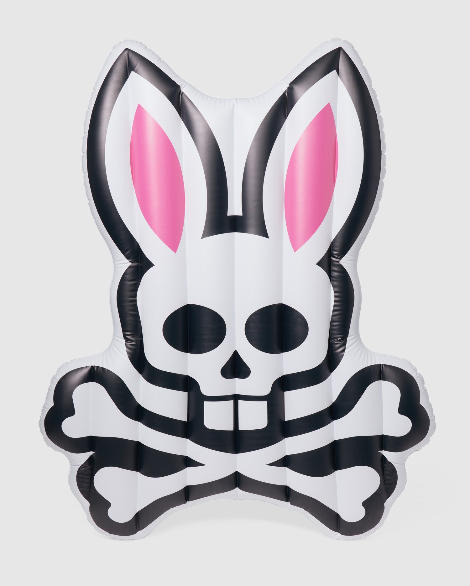 An inflatable pool floatie in the shape of a stylized rabbit's head with pink ears and a skull and crossbones design on the front, this Psycho Bunny POOL FLOATIE - B6A386B200 is primarily white with black accents. Perfect for your next resort vacation, it will make a fun and edgy statement in any pool setting.