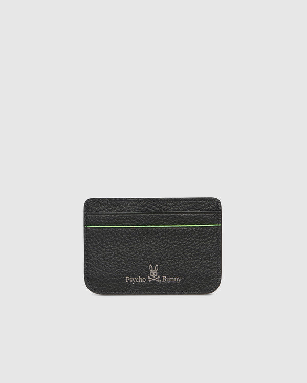 A black, compact grained leather cardholder with green trim. The CARD CASE - B6A409B200 features the Psycho Bunny patch and text on the front, showcasing a minimalist design with card slots visible at the top. The background is plain white.