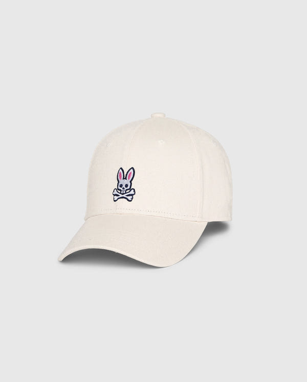 This MENS CLASSIC BASEBALL CAP from Psycho Bunny, SKU B6A816B200, is crafted from 100% cotton in a classic beige color. It features a small embroidered logo of a pink bunny with crossbones on the front and is designed with a curved brim and six panels topped with a button.