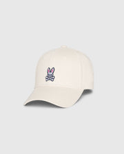 This MENS CLASSIC BASEBALL CAP from Psycho Bunny, SKU B6A816B200, is crafted from 100% cotton in a classic beige color. It features a small embroidered logo of a pink bunny with crossbones on the front and is designed with a curved brim and six panels topped with a button.