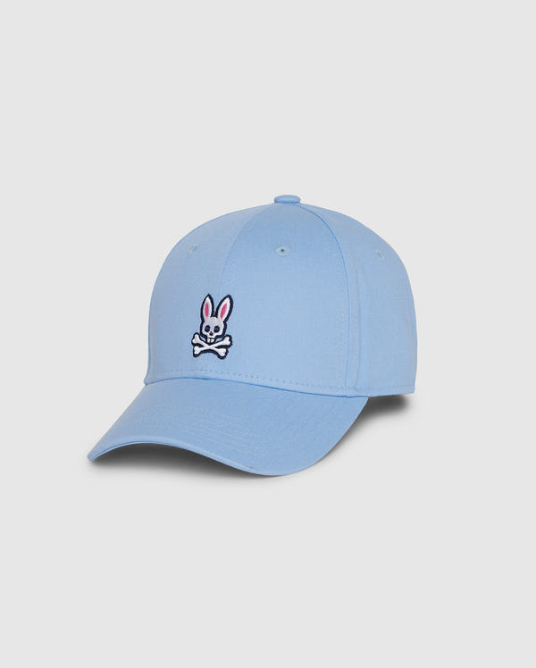The Psycho Bunny Men's Classic Baseball Cap (B6A816B200) is a light blue cap made from 100% cotton, featuring an embroidered playful cartoon bunny and skull design on the front. It comes with a curved brim and a top button, all on a simple white background.