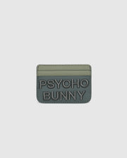The MENS WORDMARK LEATHER CARD CASE - B6A869D200 by Psycho Bunny is a green, minimalist leather card holder made from durable shell pebble leather. It features two card slots, "PSYCHO BUNNY" embossed on the front with raised text, and a soft matte finish.