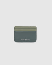 The MENS WORDMARK LEATHER CARD CASE - B6A869D200 by Psycho Bunny is crafted from durable shell pebble leather in two shades of green. It features the brand name and a small white logo at the bottom, ideal for organizing any man's essentials.
