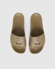 A pair of brown pool slides with an embossed cartoon rabbit face design on each top strap, viewed from above on a white background are the MENS LOGO SLIDES - B6A910U1FT by Psycho Bunny.