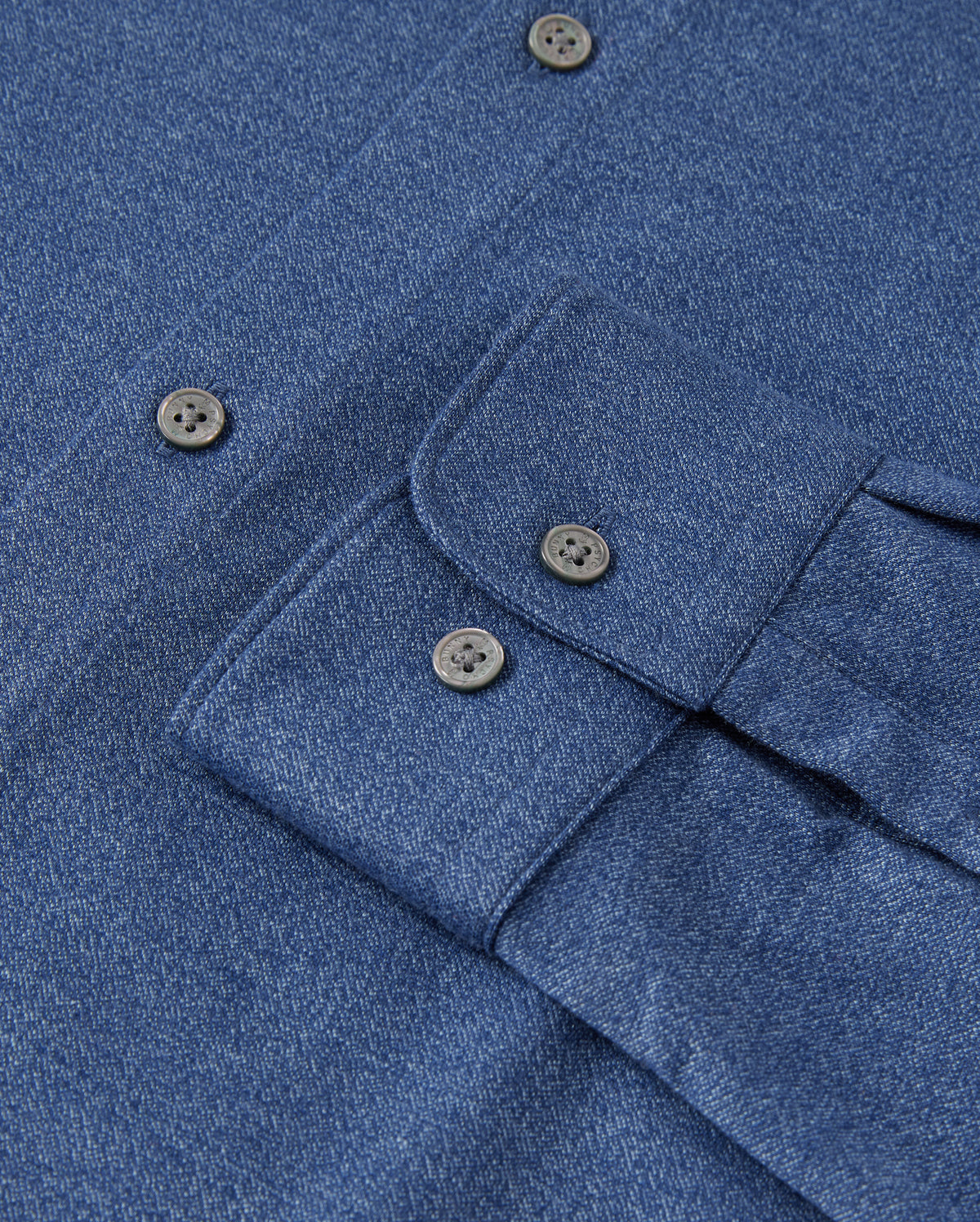 Close-up of a Psycho Bunny MENS DALTON KNIT SHIRT in blue, crafted from Peruvian Pima cotton with black buttons. It's neatly folded to showcase the button-down collar and part of the placket. Product code: B6C747D200.