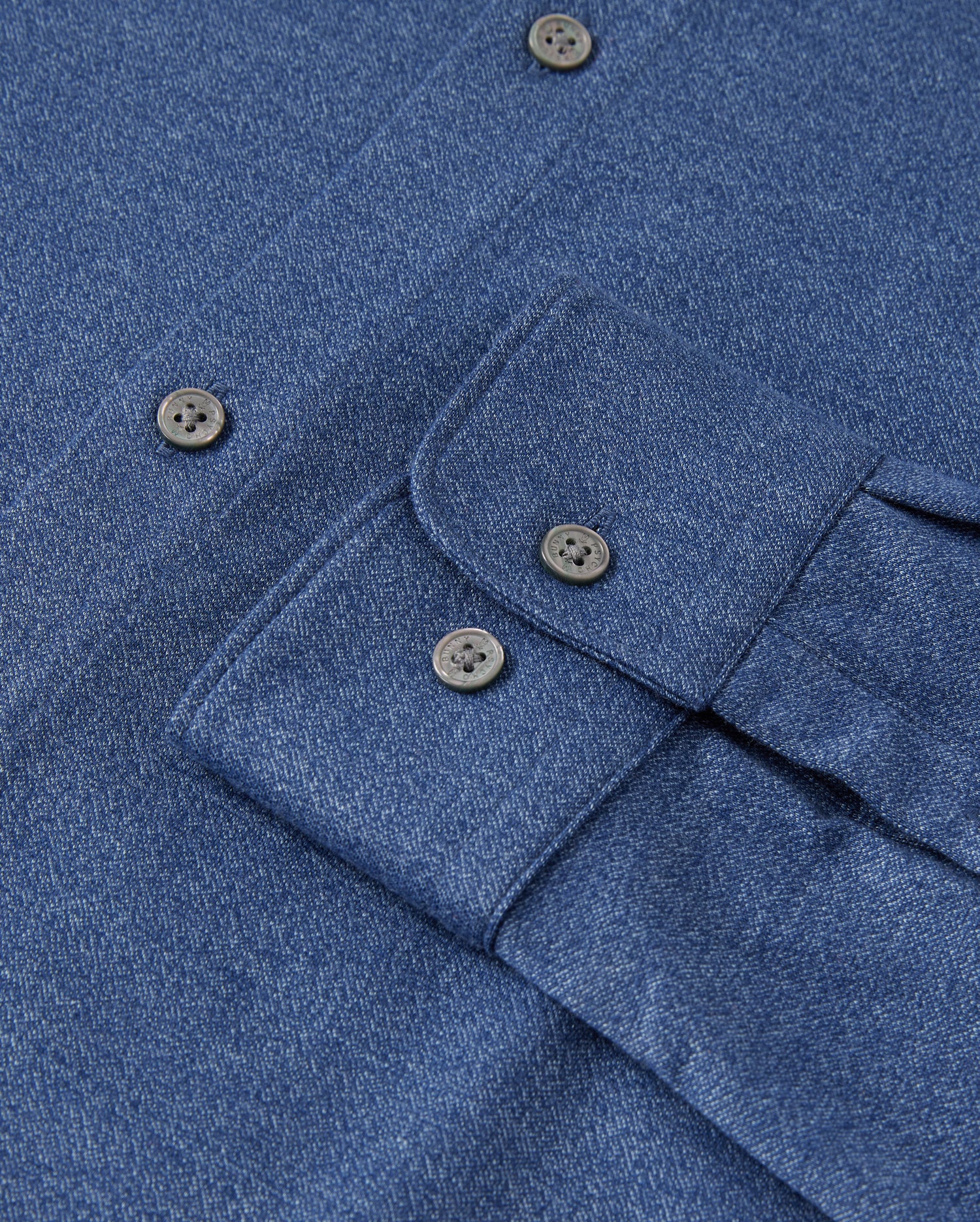 Close-up of a Psycho Bunny MENS DALTON KNIT SHIRT in blue, crafted from Peruvian Pima cotton with black buttons. It's neatly folded to showcase the button-down collar and part of the placket. Product code: B6C747D200.