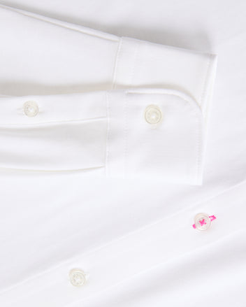 Get a closer look at the timeless MENS ARTHUR JERSEY SHIRT - B6C748D200 from Psycho Bunny, made from smooth stretch Pima cotton. It showcases a sleeve cuff with two white buttons and a distinctive pink button on the shirt front.