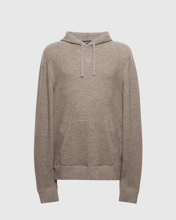 The MENS LEVAN WAFFLE HOODED SWEATER - B6E246E200 by Psycho Bunny is a beige knitted hoodie with a front pocket, drawstring hood, and textured weave using cozy wool-cashmere blend. An embroidered chest bunny adds charm, ideal for casual or cool weather.