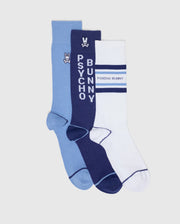 The MENS 3 PACK DRESS SOCK B6F504F200 by Psycho Bunny includes a light blue pair with a small logo, a navy pair featuring vertical "PSYCHO BUNNY" text and logo, and a white pair with navy stripes and horizontal "PSYCHO BUNNY" text—perfect for stylish ensembles.