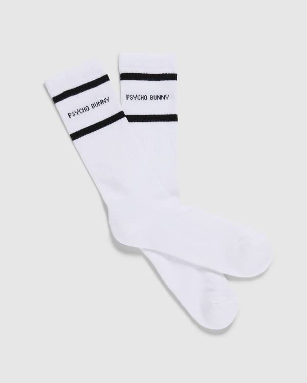 This pack includes three pairs of Psycho Bunny men's sport socks (MENS 3 PACK SPORT SOCK - B6F997D200), each featuring black stripes near the top and crafted from luxurious Peruvian Pima cotton. The phrase "PSYCHO BUNNY" is elegantly written in black between the two stripes, all showcased against a plain light grey background.