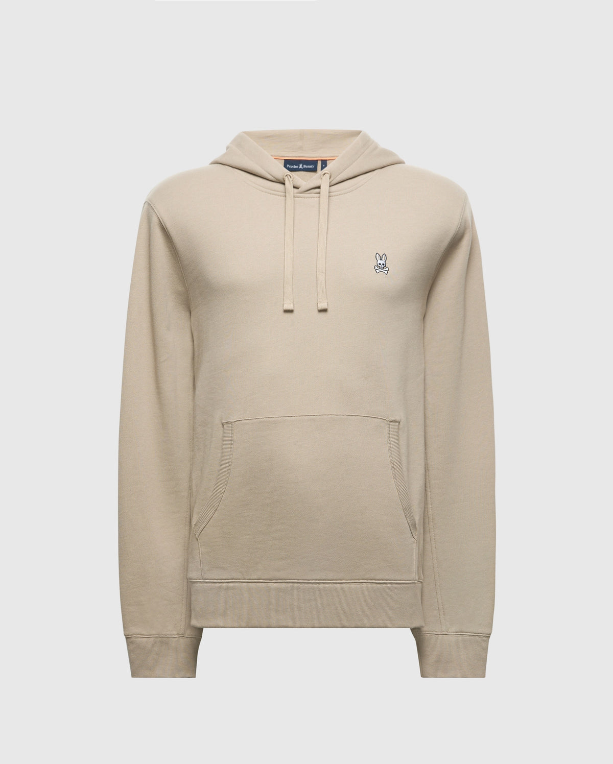 The MENS LEVY ESSENTIAL FLEECE HOODIE by Psycho Bunny is a beige cotton hoodie designed for men, featuring a front pocket and drawstring hood. It showcases a small, embroidered bunny logo with crossed eyes on the left chest. The fleece hoodie is set against a light gray background.