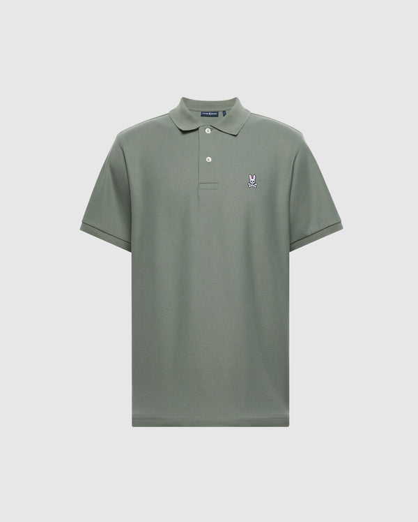 Introducing the MENS CLASSIC PIQUE POLO SHIRT - B6K001B200 by Psycho Bunny. This short-sleeved, sage green polo features a buttoned collar and is crafted from soft Pima cotton. It is adorned with a small embroidered Bunny logo on the left chest, set against a plain light grey backdrop.