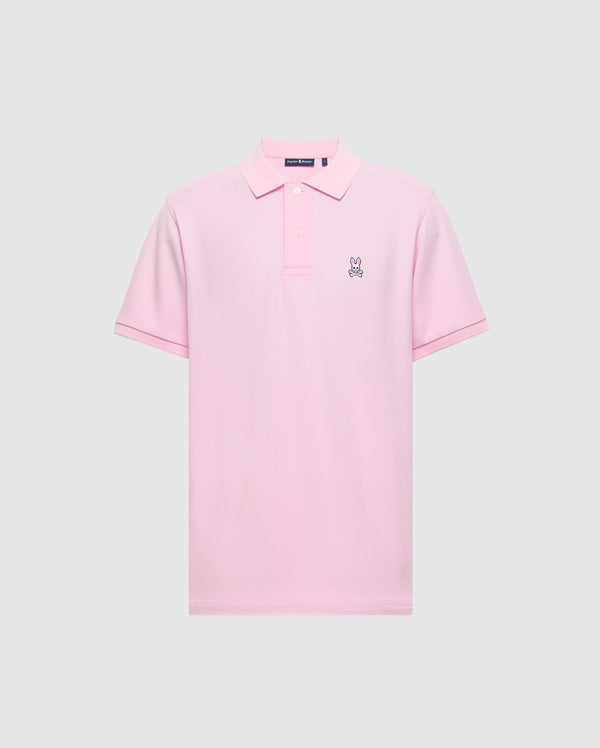 The Psycho Bunny Men's Classic Pique Polo Shirt - B6K001CRPC, is a pink polo made from soft Pima cotton. It features a small embroidered rabbit logo on the left chest, a classic collar, and a button placket against a plain light gray background.